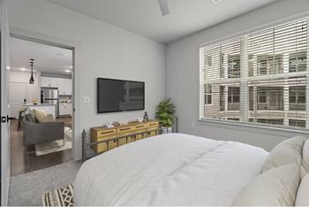 A bedroom with a large bed and a flat screen TV mounted on the wall.